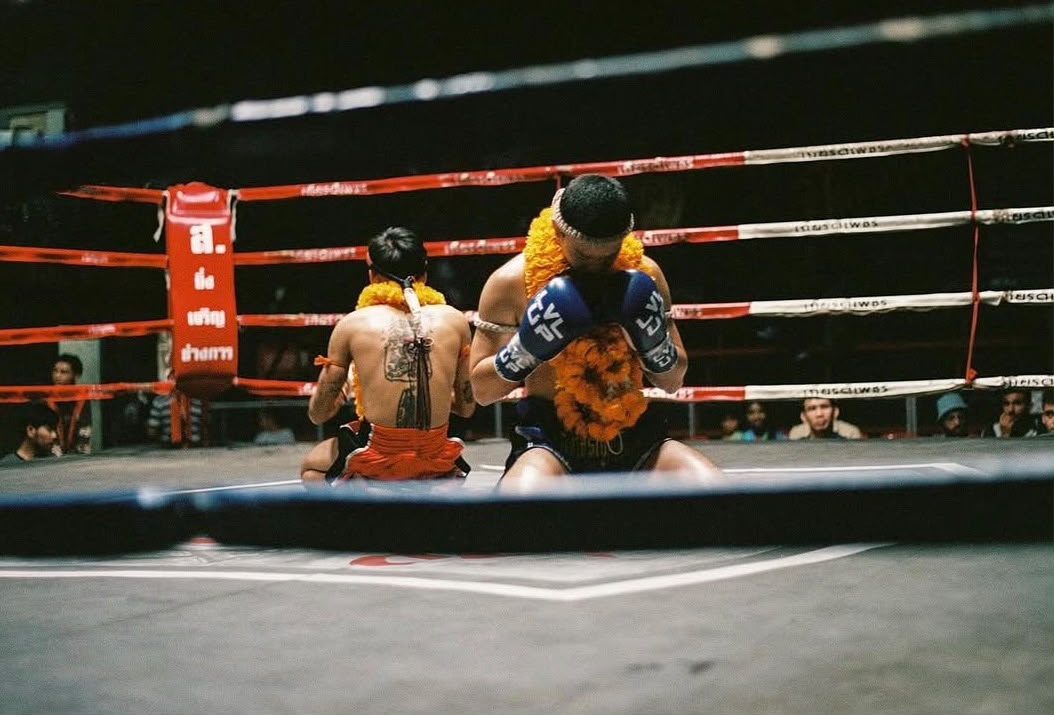 Two Muay Thai fighters exchanging blows in the ring